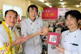 山田錦バウムの「優勝」を祝福するユーハイムの藤本浩二さん（左）と稔樹の田中誠さん（中央）、打越稔明さん＝三木市別所町東這田