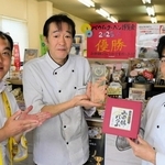 山田錦バウムの「優勝」を祝福するユーハイムの藤本浩二さん（左）と稔樹の田中誠さん（中央）、打越稔明さん＝三木市別所町東這田