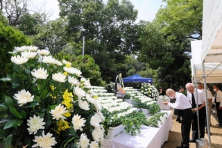 白菊を手向け、手を合わせる遺族ら＝三木市上の丸町