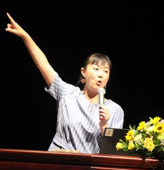 紛争地域などで撮影した写真をスライド上映しながら話すフォトジャーナリストの安田菜津紀さん＝三木市文化会館