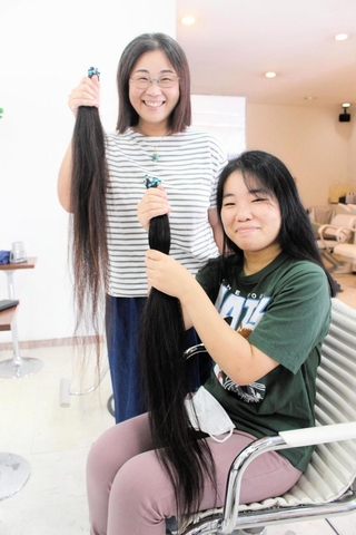 切った長さは２人とも80～90センチ。「８年半の成果」と笑う神吉さん親子＝三木市跡部