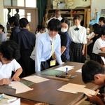 美術の体験授業でペーパークラフトに挑戦する中学生を見守る高校生（中央）＝三木市別所町小林