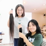 切った長さは２人とも80～90センチ。「８年半の成果」と笑う神吉さん親子＝三木市跡部