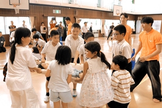 自分たちで作った担架に友だちを乗せて、慎重に運ぶ子どもたち＝志染小学校