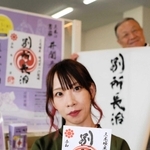 別所長治の文字が書き込まれた武将印を持つ井関春龍さん＝三木市末広１、三木市観光協会