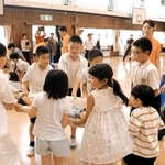 自分たちで作った担架に友だちを乗せて、慎重に運ぶ子どもたち＝志染小学校