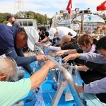 給水車からの水を専用の袋に入れる実際の動きを学ぶ参加者ら＝三木山総合公園