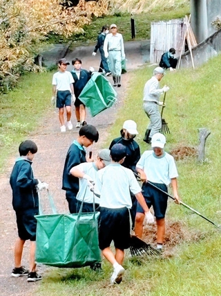 滝に向かう散策道を清掃する「黒滝」憩いの場つくりの会のメンバーと生徒たち＝三木市吉川町金会（同会提供）
