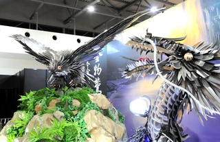 越前打ち刃物の「昇龍」（右）と並んで来場客を出迎えた三木の金物鷲＝７月２８日、大阪市此花区