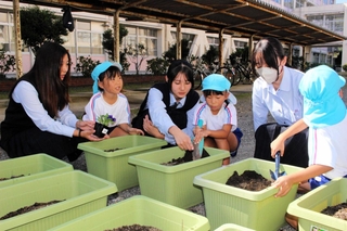 花植えを通して園児らと交流する吉川高校生＝三木市吉川町渡瀬