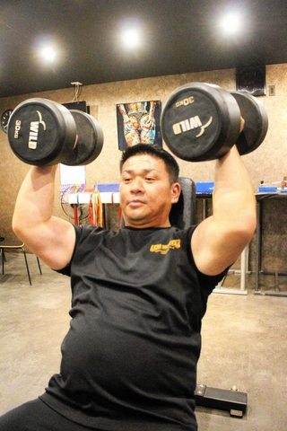 トレーニングに集中する澤田さん。３０キロのダンベルは「ウオーミングアップです」＝三木市加佐