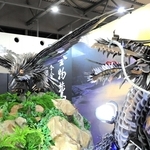 越前打ち刃物の「昇龍」（右）と並んで来場客を出迎えた三木の金物鷲＝７月２８日、大阪市此花区