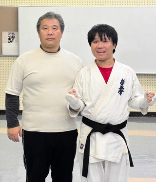 初めて黒帯を締めた近野凌太朗さん（右）と父の一弘さん＝三木市立総合隣保館