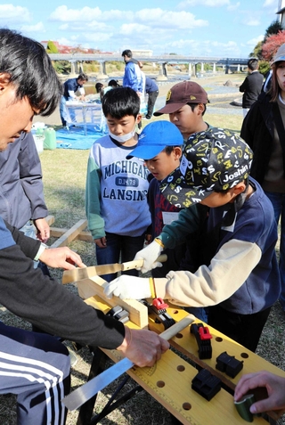 鋸を使った仕事に取り組む子どもたち。この後「お給料」を手にした＝三木市本町２