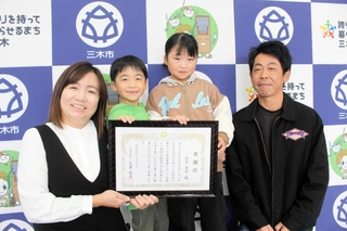 感謝状を手に笑顔の（左から）松井奈央さんと長男一真さん、長女一華さん、夫の弘幸さん＝三木市福井