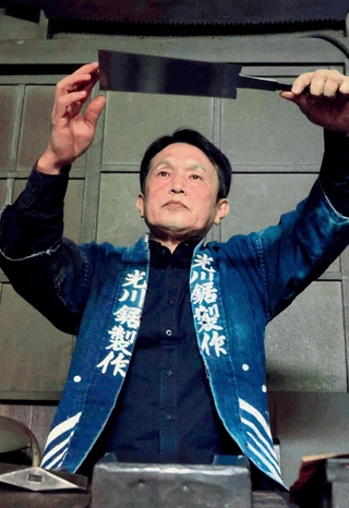 鋸のひずみを見る光川大造さん。伝統工芸士として後進育成に尽力する＝三木市別所町高木