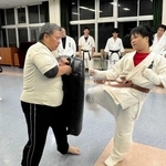 昇段審査の組手で、最後に近野凌太朗さん（手前右）の蹴りを受ける父一弘さん＝三木市立総合隣保館