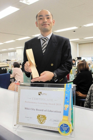 三木市教育委員会が受賞した「パフォーマンスラーニングデザイン賞」の賞状とトロフィー＝三木市役所