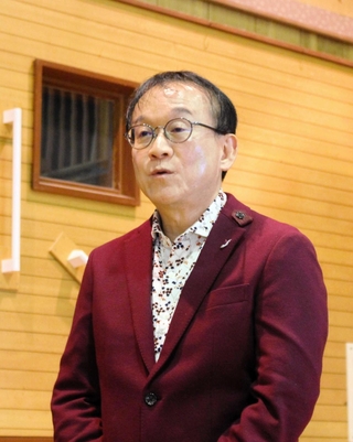 三木市高齢者大学の学生と一緒に「しあわせ運べるように」を歌う臼井真さん＝三木市細川町瑞穂