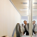 藤原義明さん（奥）の４６年に及ぶ作陶の成果が並ぶ会場＝堀光美術館