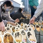 絆や希望などの祈りが書き込まれた竹灯籠に明かりをともす参加者＝三木市末広１