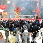 桜に見立てた枝を持って舞台に上がった鬼を見守る参拝客＝大宮八幡宮