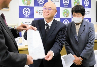 口吉川地域の医療の維持について仲田一彦市長に要望書を手渡す口吉川ふれあいまちづくり協議会の密祐浩会長（中央）＝三木市役所