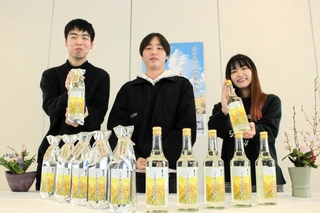 自分たちが田植え、収穫などを体験した山田錦で醸造された日本酒をお披露目する学生ら＝ＪＡみのり吉川営農経済センター