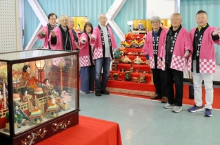 華やかなひな飾りとともに出迎えてくれる「ふれっぴーみき」のメンバー＝中央公民館