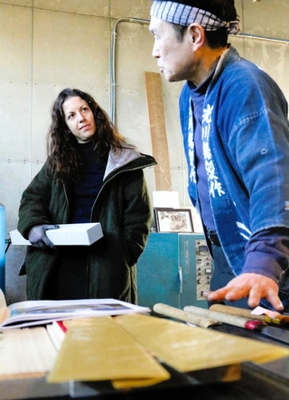 播州三木打刃物の伝統工芸士、光川大造さん（右）の話に目を輝かせるニーナ・フラデさん＝三木市別所町高木