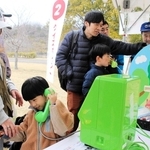 クイズラリーの道中で災害用伝言ダイヤルの仕組みを学ぶ親子ら＝県立三木総合防災公園