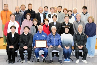 感謝状を手に白い歯を見せる冨依多雅蔵さん（前列左から３人目）を囲む三木市スポーツ推進委員ら＝三木市立教育センター