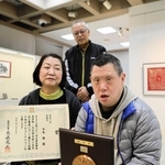 母和美さん（左）と藤原常貴さん（奥）に見守られて県知事賞の盾を手にする中尾徹さん＝三木市立堀光美術館