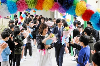 感無量の表情で児童たちに手を振る井上紀代美前校長（中央）ら＝自由が丘東小学校