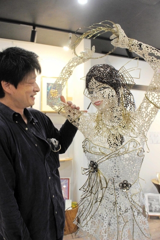 金具を溶接して形作った等身大の女性像と佐藤憲一さん（左）＝三木市与呂木