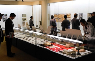 出土品や写真パネルをじっくりと見る来館者ら＝みき歴史資料館