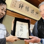 書家上田桑鳩が手がけた随筆集「駄想録」を受け継いだ北村直子さん（左）と夫の健さん。壁には「錦谷」時代の書も掲げられている＝三木市大塚２