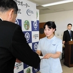 仲田一彦市長（左）から委嘱状を受け取る看護学科４年の今村心愛さん＝関西国際大学三木キャンパス