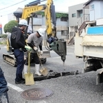 陥没でできた穴を掘り、原因を調べる作業員ら＝三木市府内町
