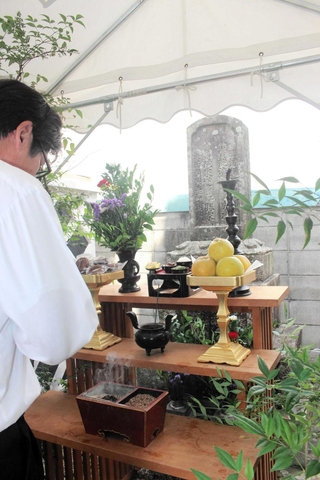 「夏の義民祭」で墓前で手を合わせる参列者＝三木市本町２、本要寺