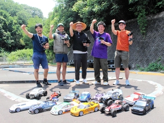 炎天下でも「ラジコン、楽しい」。愛車を前に笑顔を見せるメンバーら＝三木市吉川町大畑