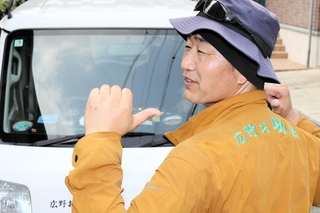 「広野お助隊」の文字を背に汗を流す北芝さん＝三木市志染町広野６