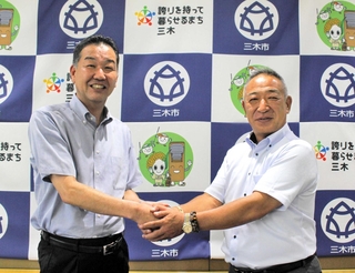 仲田一彦市長（左）にＷＣＢＣ優勝を報告する鈴木英之監督＝三木市役所