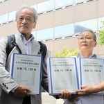 集めた署名を手にする菅野みずえさん（右）と夫の昭雄さん＝大阪市北区