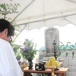 「夏の義民祭」で墓前で手を合わせる参列者＝三木市本町２、本要寺