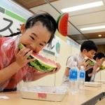 スイカの早食い競争でかぶりつく子どもら＝道の駅よかわ
