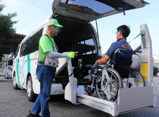 車椅子ごと乗車可能な車両を操作する送迎ボランティアの男性（左）。安全性の確認に余念がない＝三木市末広１