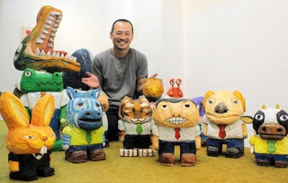 ユニークな彫刻作品と作者のくしげまちしょうごさん＝三木市立堀光美術館
