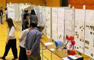 日ごろの疑問を児童生徒が調査し、成果をまとめた作品を見る来場者＝三木南交流センター
