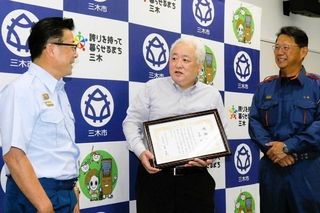 大東成吉消防長（左）と初期消火について振り返る箕田尚さん（中央）＝三木市消防本部